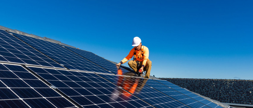 Mann der einen Solaranlage installiert auf dem Dach eines Hauses