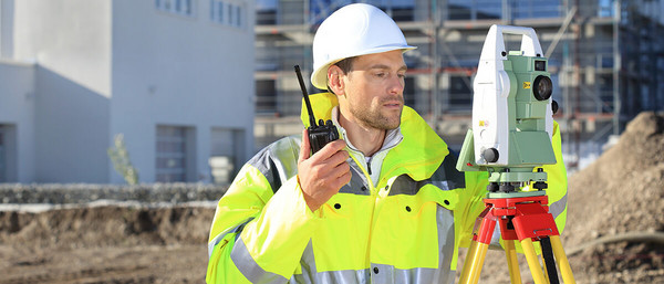 Bauarbeiter mit Vermessungsgerät auf Baustelle
