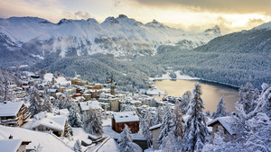 Verschneites Bergdorf vor einem See
