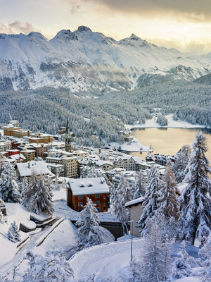 Verschneites Bergdorf vor einem See