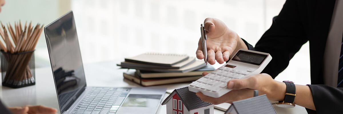 Frau hält Modellhaus in der Hand