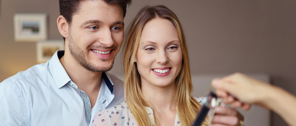 Paar erhält Schlüssel und lacht