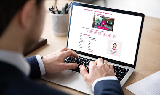 Mann sitzt vor einem Laptop und sieht sich ein Immobilieninserat an