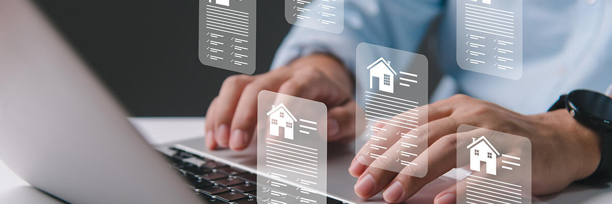 Mann tippt auf Laptop mit Immobilienicons