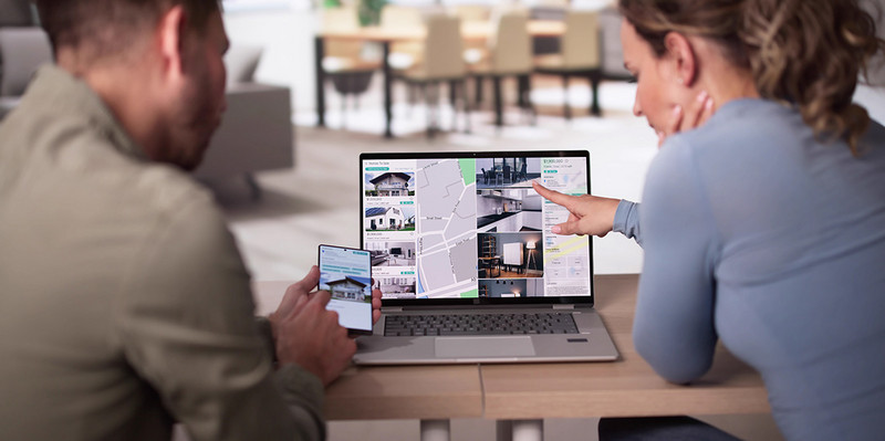 Paar zeigt auf Laptop mit Immobilieninseraten