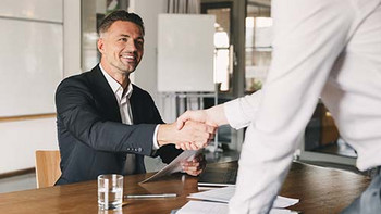 Zwei Personen begrüssen sich zum Bewerbungsinterview