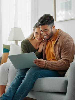 Glückliches Pärchen auf digitaler Wohnungssuche