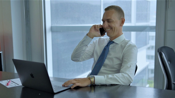 Makler ist im Büro am Telefon und lacht