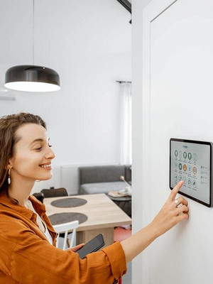 Junge Frau tippt auf ihrem Smart Home Tablet