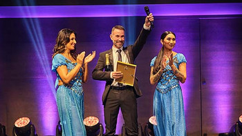 Junger Makler im Anzug an einem Firmenfest