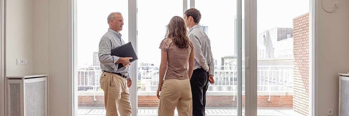 Makler zeigt Paar moderne Wohnung 