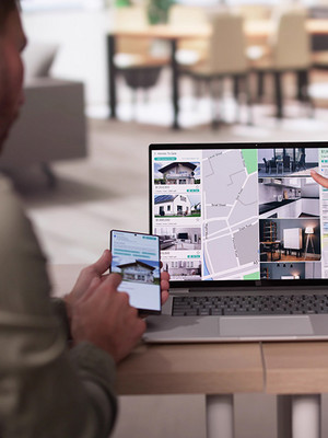 Paar zeigt auf Laptop mit Immobilieninseraten